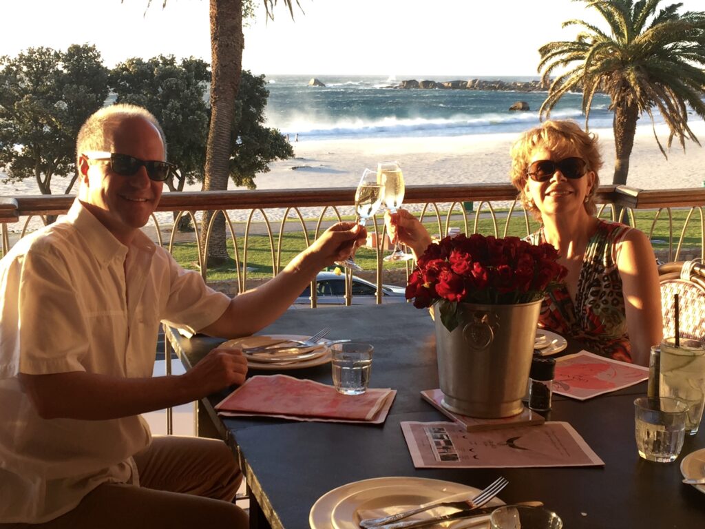 couple-at-a-restaurant-on-the-beach-toasting-champagne