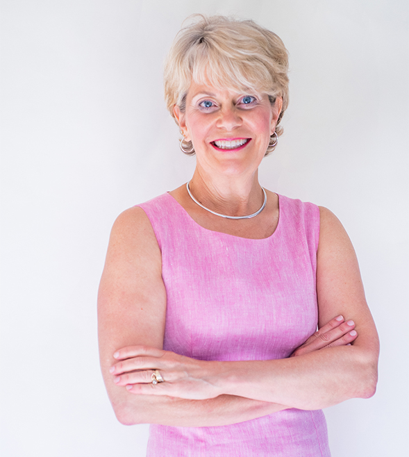woman-standing-arms-crossed-headshot-wearing-a-pink-dress