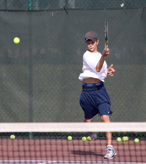 boy-playing-tennis-balls-racket-net